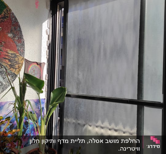 חלון עם מסגרת מתכת, חוט ורוד תלוי מהתקרה